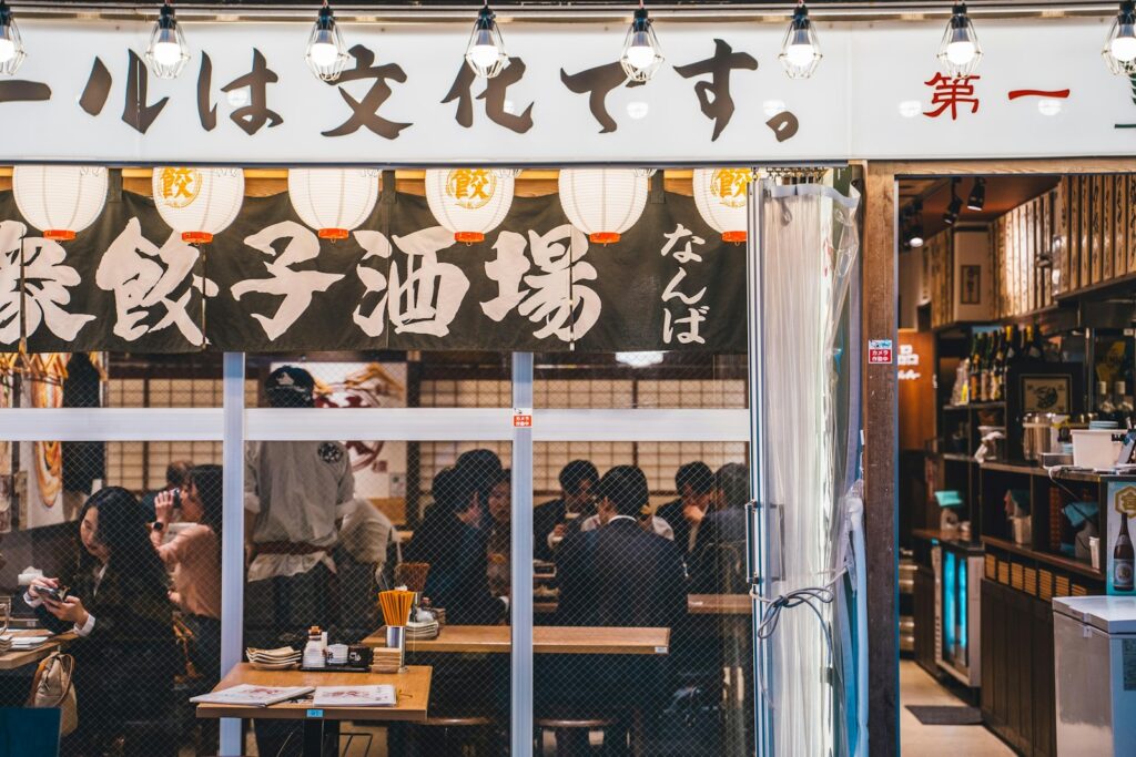 a group of people sitting at a table in front of a restaurant