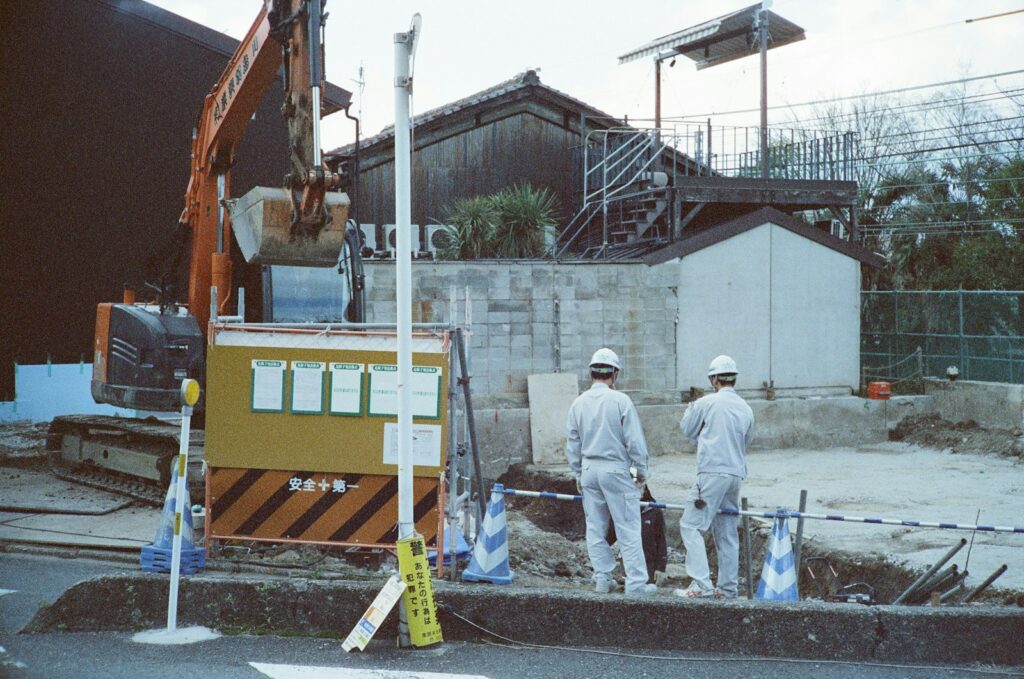 Construction workers observing an excavator on the construction site.