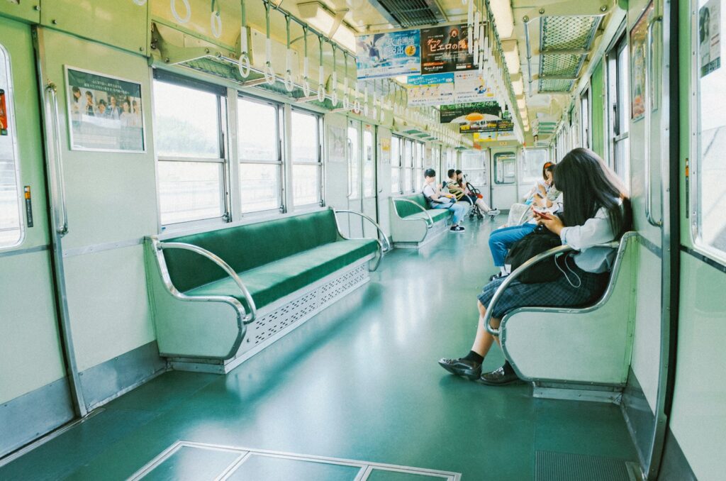 People sitting on a train with green seats